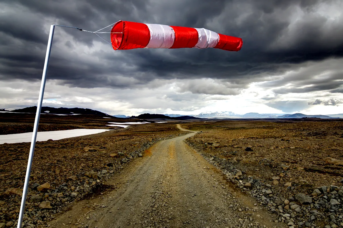 Windsock on a windy dirt road in Iceland with stormy clouds.