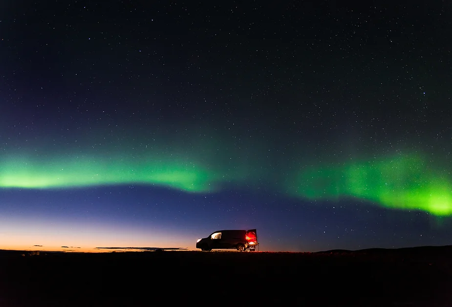 Una camper permanece estacionada en un paraje islandés desértico durante el espectáculo de las auroras boreales en mitad de la noche.
