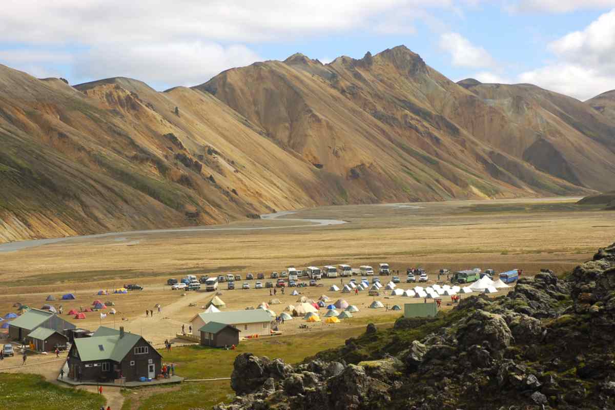 Campsite in Landmannalaugar with tents, vehicles, and colorful rhyolite mountains