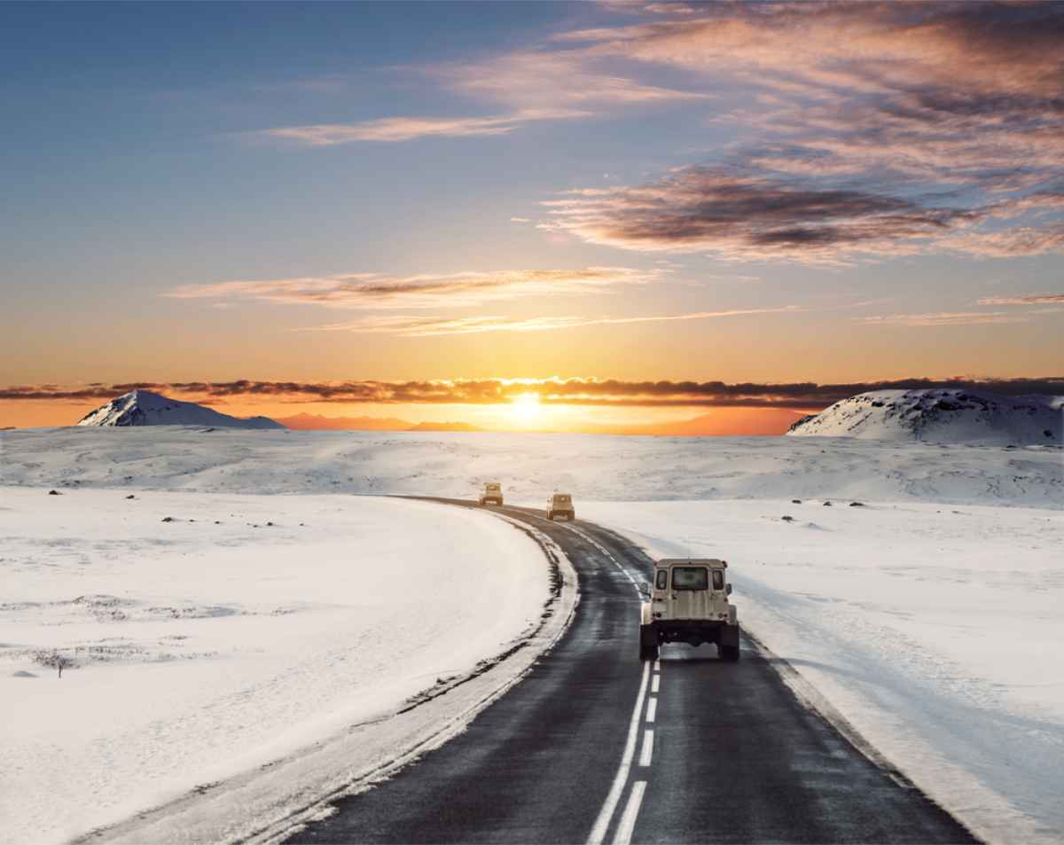 Iceland's ring road covered in snow with several jeeps in a row