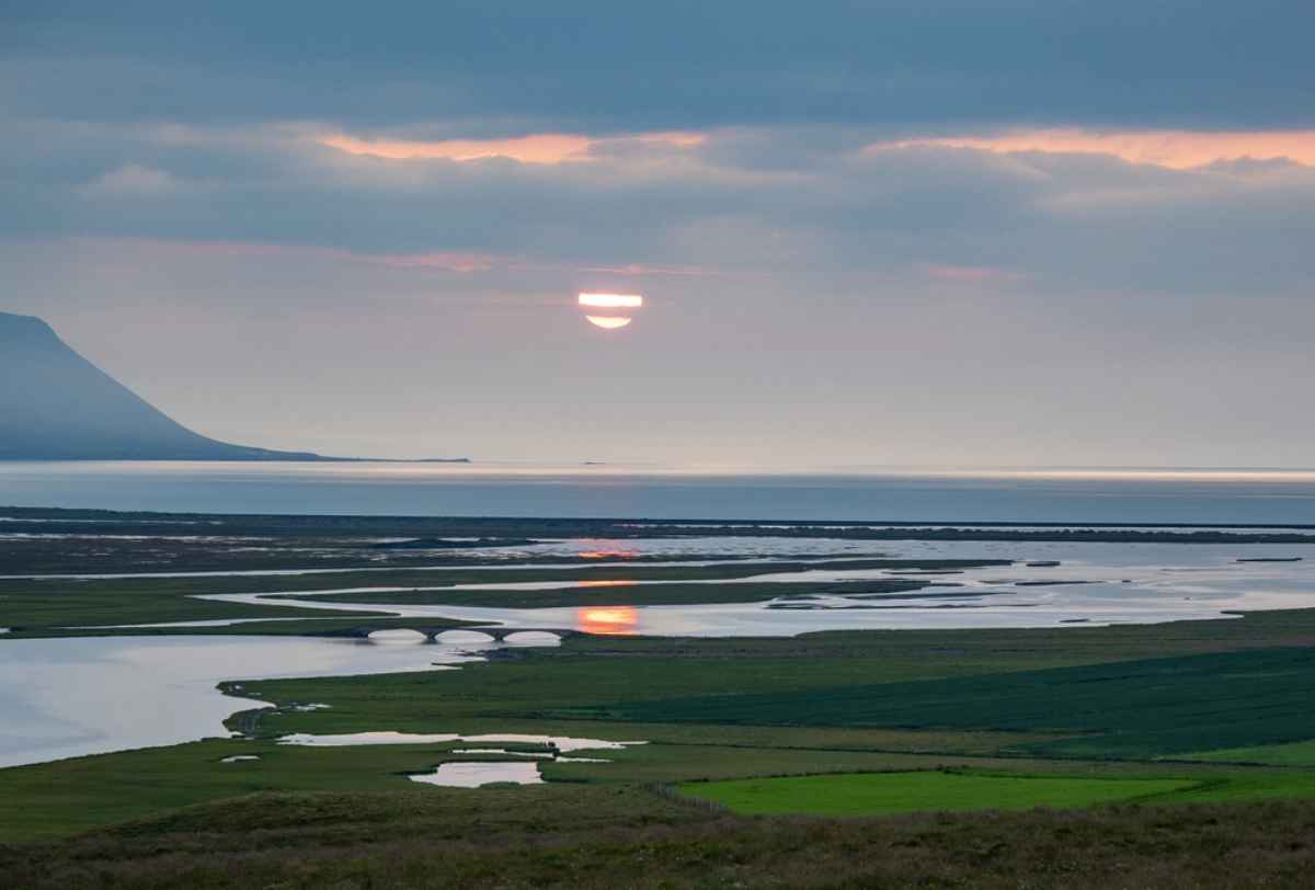 Sunset over Icelandic wetlands and coastal waters in August.