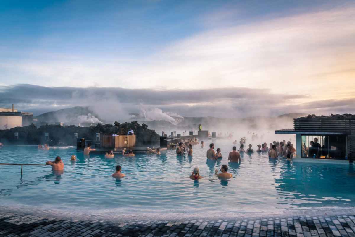 A group of tourists enjoy a well-deserved swim in the warm waters of the Blue Lagoon, one of the most spectacular thermal lagoons in Iceland.