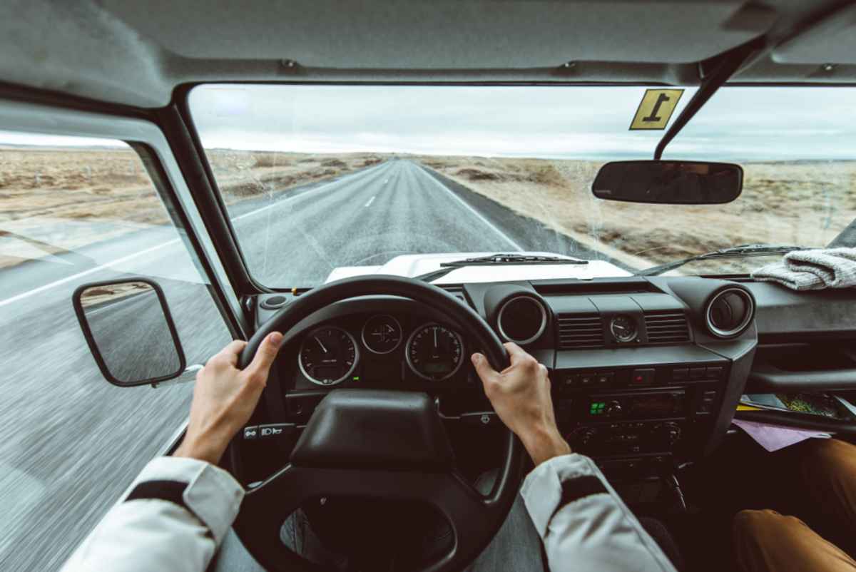 A person drives a vehicle on an Icelandic road plagued by adverse winter weather conditions.