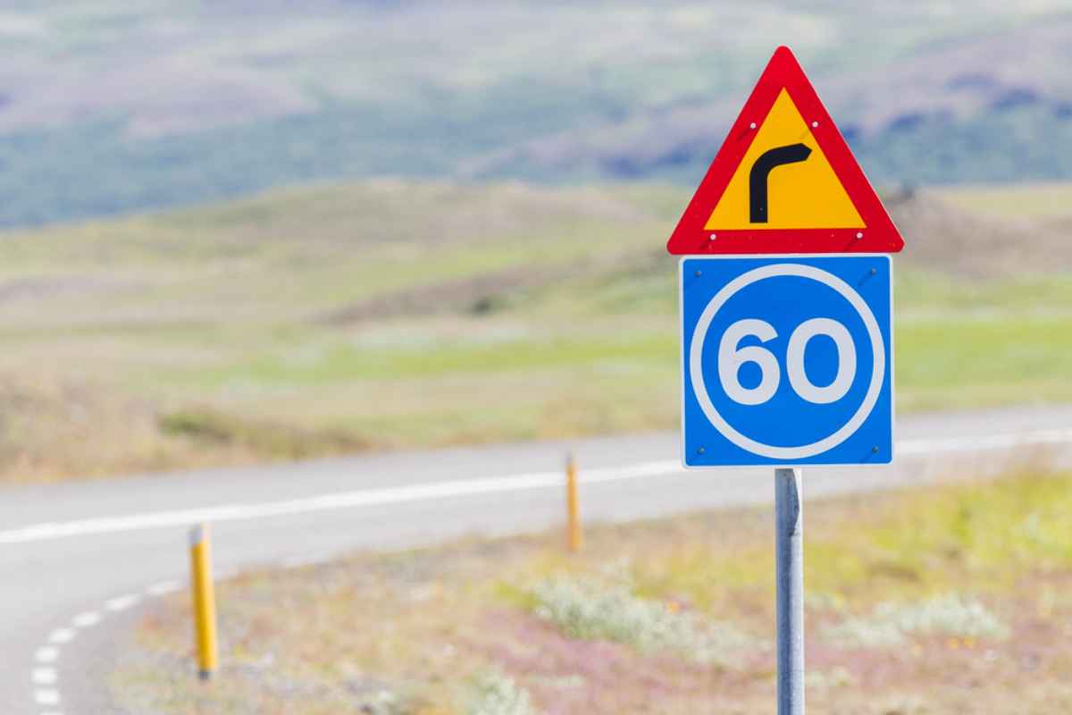 Una señal triangular en Islandia indica la necesidad de reducir la velocidad a 60 debido a la continua presencia de curvas en la carretera.