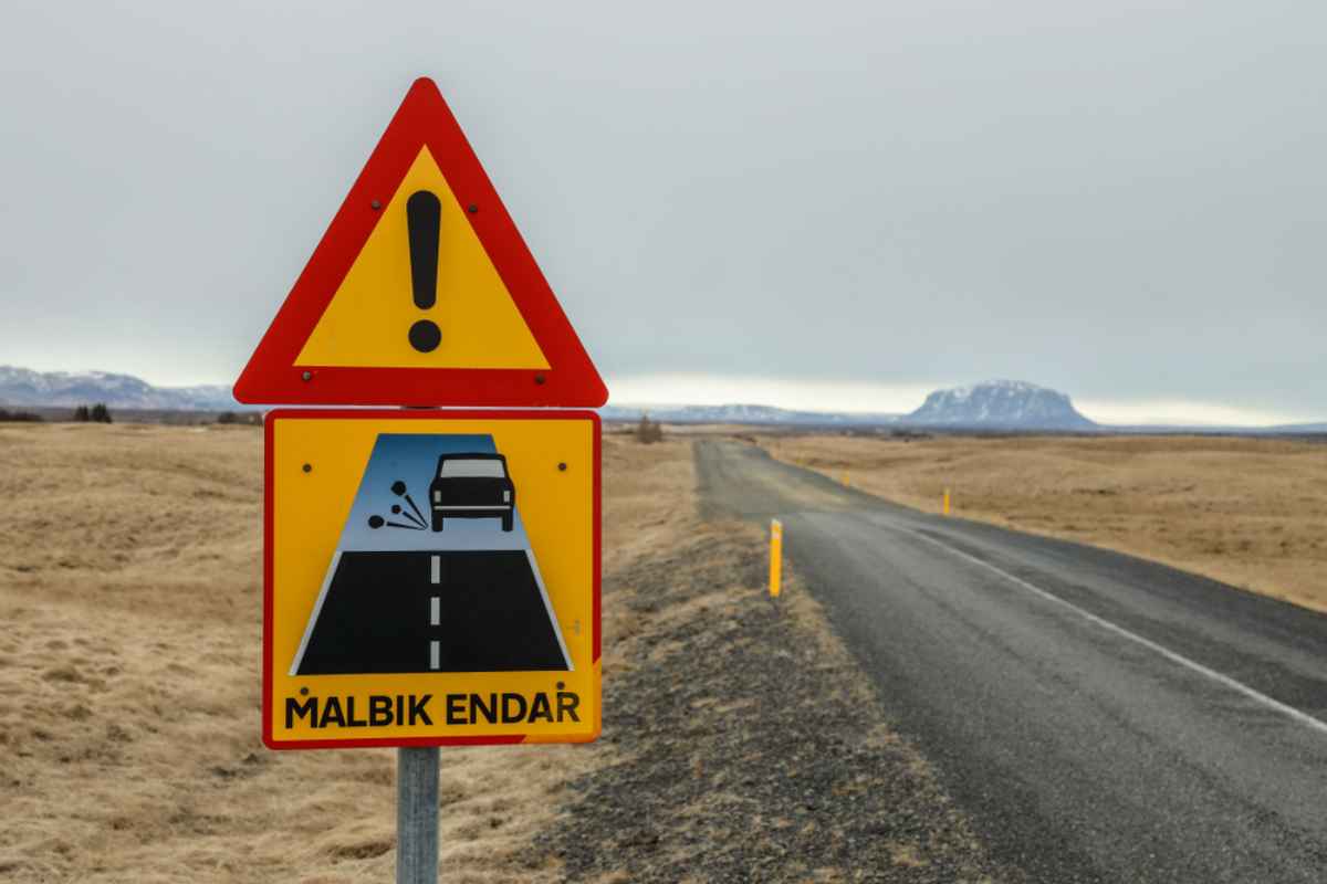 Una señal de tráfico en Islandia indica que el camino asfaltado termina bajo la inscripción en lengua local 'Malbik endar'.