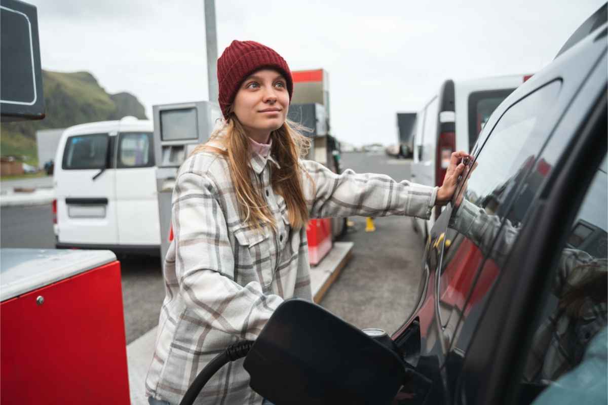Tourist filling up her campervan tank at a gas station