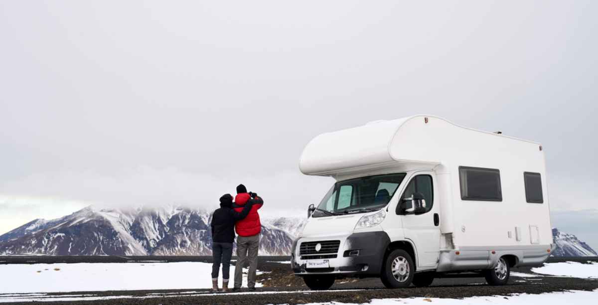 A couple enjoying the landscape while standing right by their white motorhome
