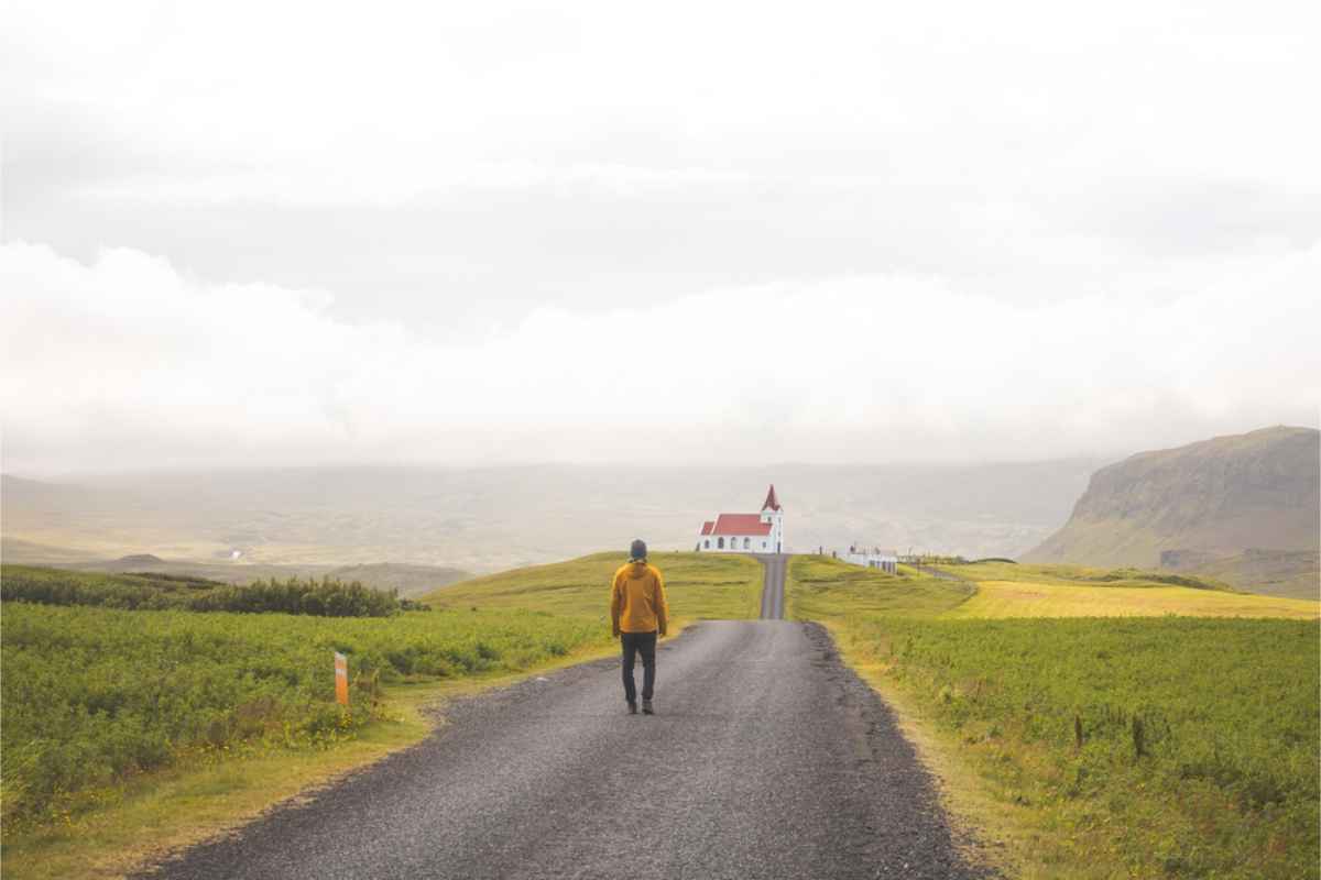 Man walking up to Vik's main church which is on top of a hill