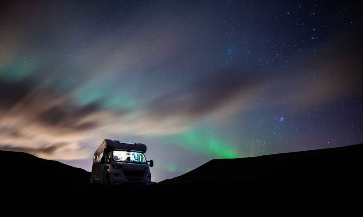 Mmotorhome parked with the Northern Lights dancing above