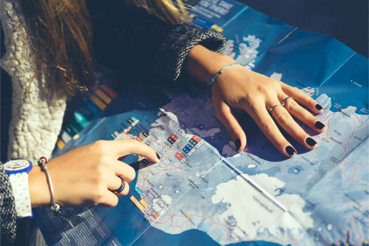 Tourist with a map of Iceland pointing at the southern region of the country