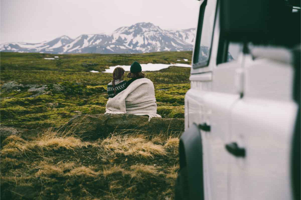 young couple enjoying the Icelandic landscape near their camper