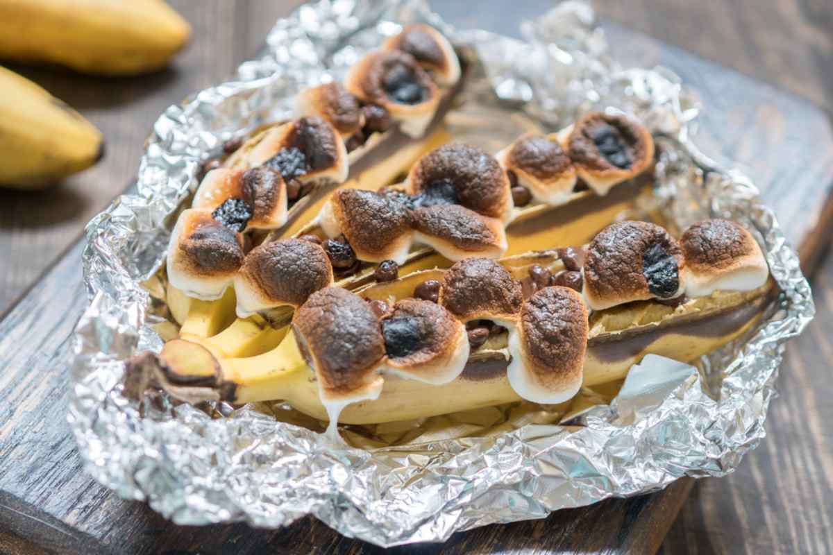 Campfire banana boats with toasted marshmallows in foil,, an easy campervan dessert.