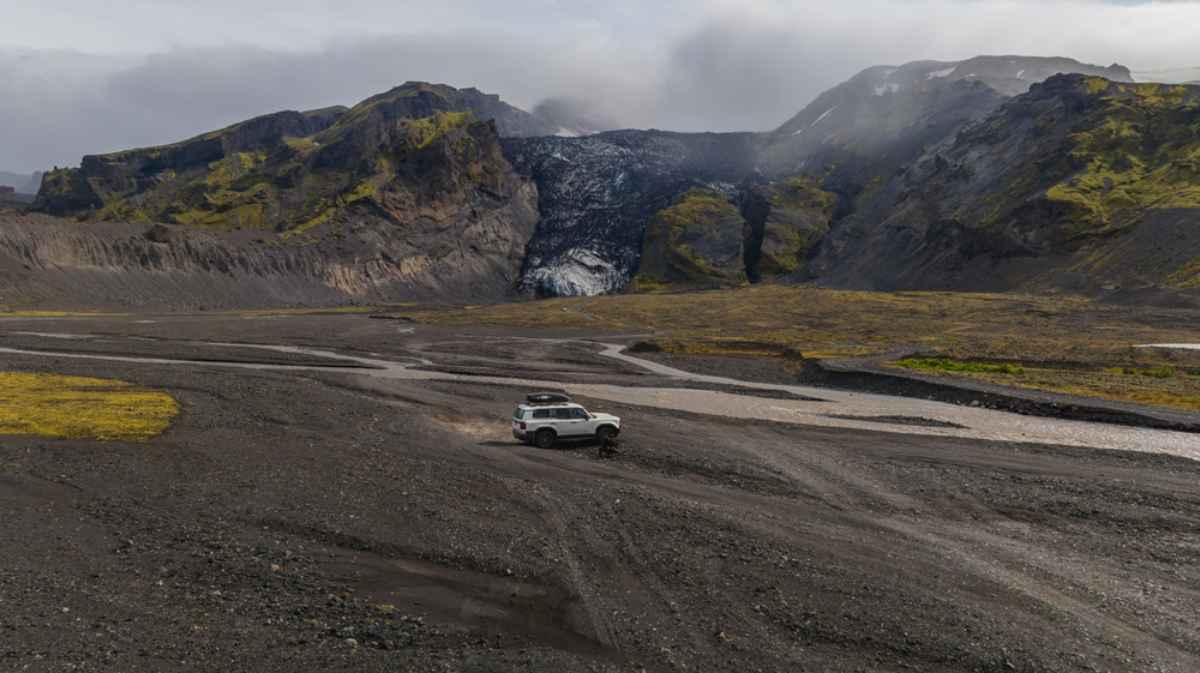Iceland's remote highlands 4x4 on remote highland tracks in Iceland with shallow rivers and a glacier-covered mountain ahead.