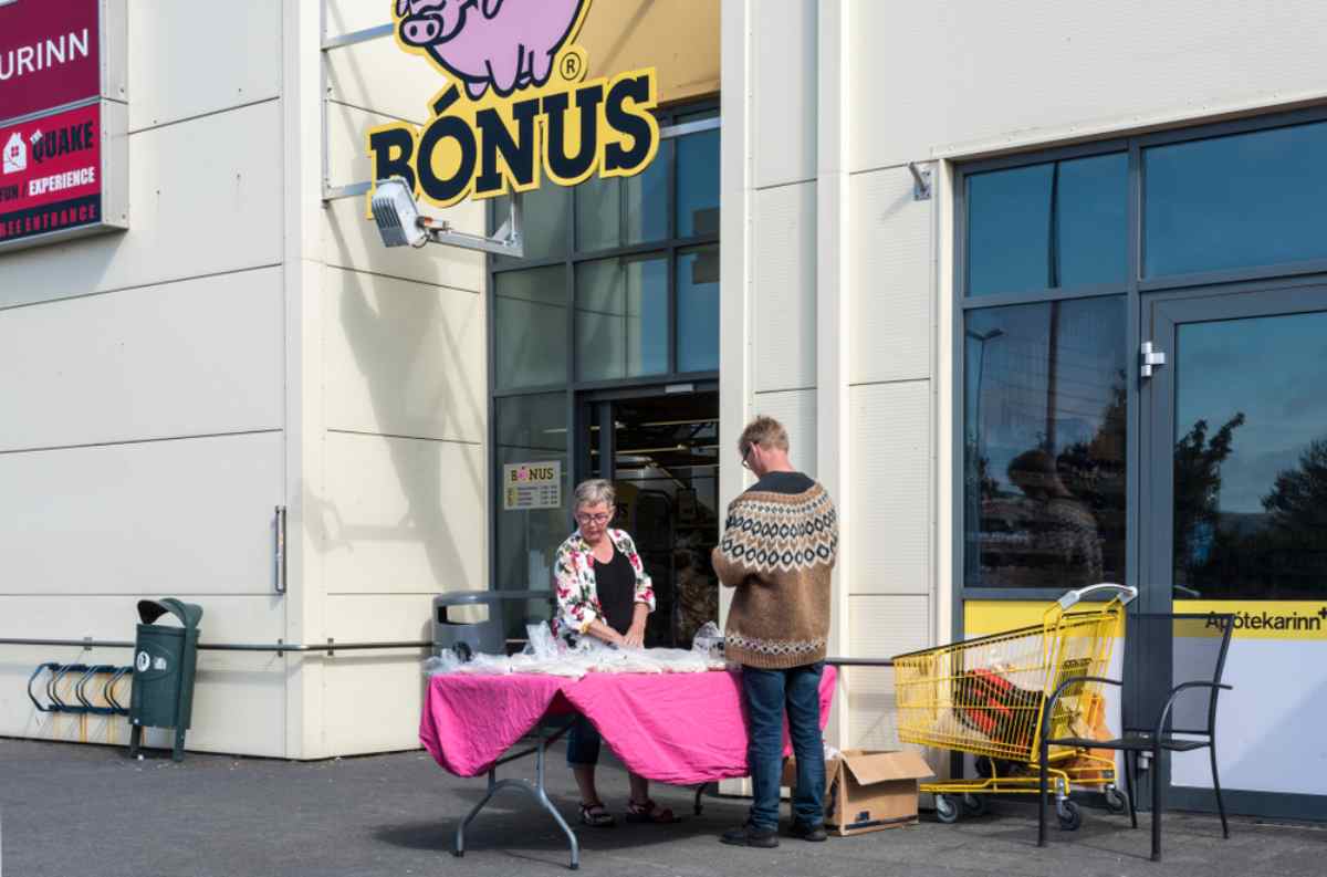 Ingresso del supermercato Bónus in Islanda con bancarella e carrello giallo.