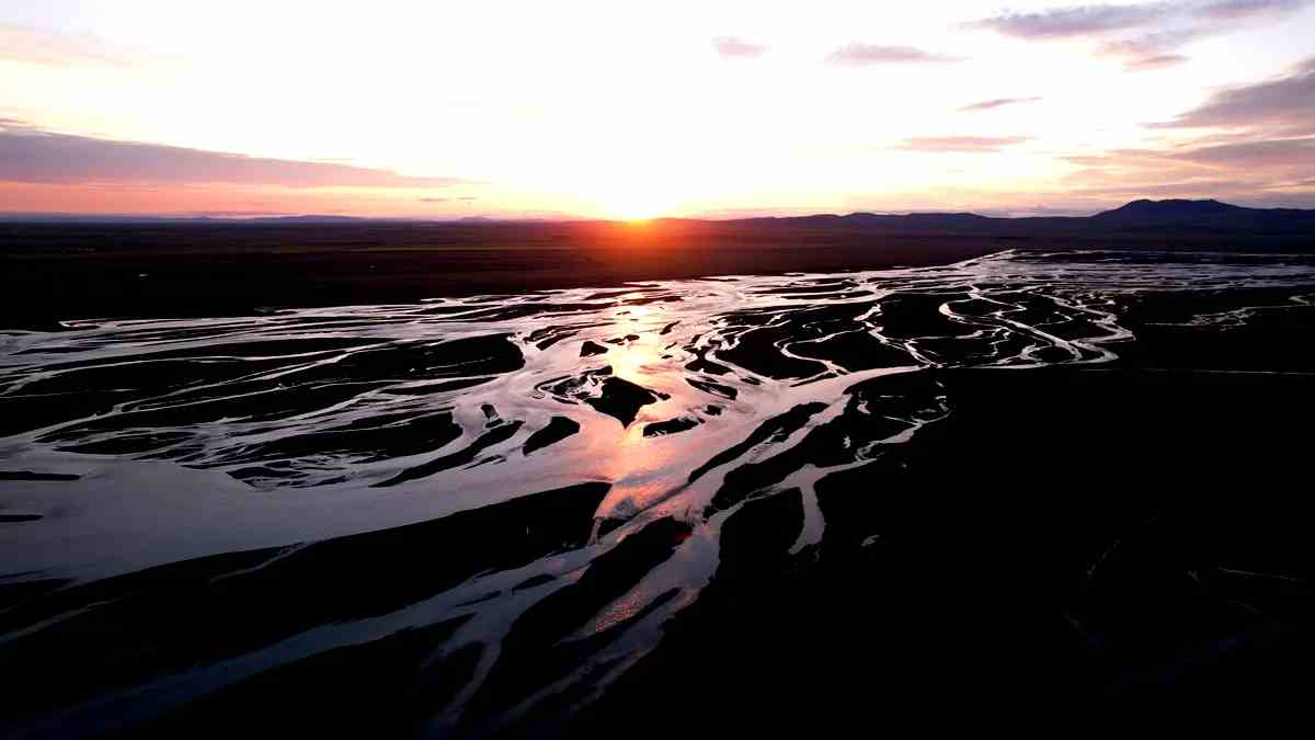 Puesta de sol sobre canales fluviales entrelazados en Islandia