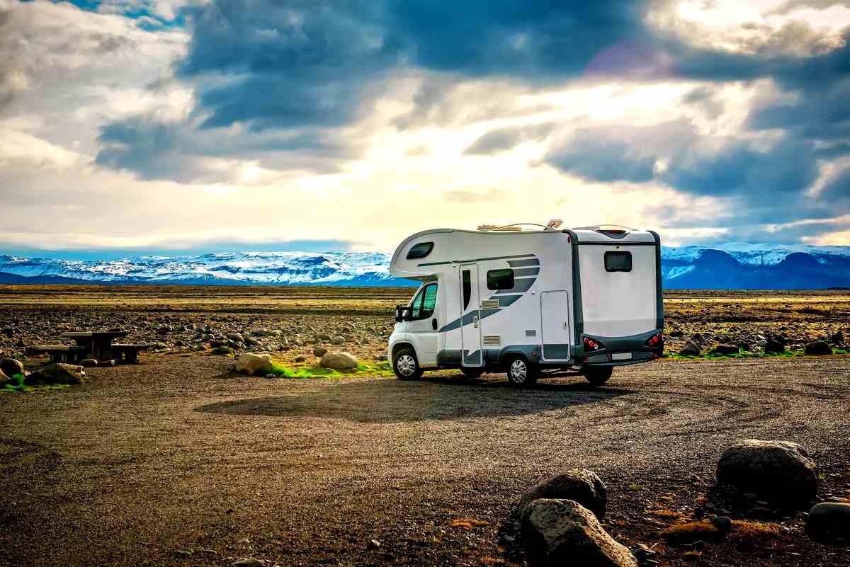Autocaravana aparcada en un amplio paisaje island&eacute;s con monta&ntilde;as al fondo