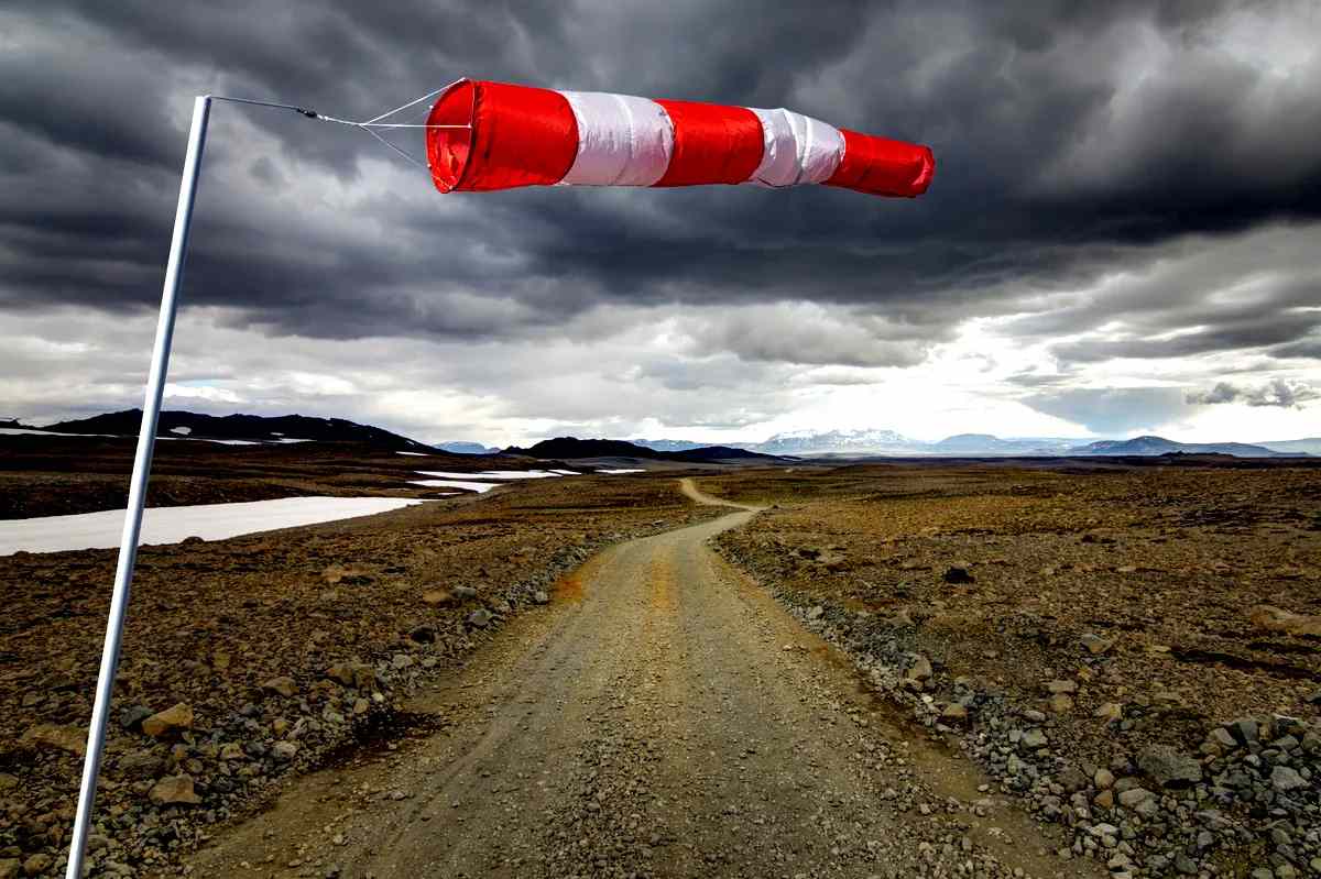 Manga de viento en un camino de tierra en Islandia con nubes de tormenta.
