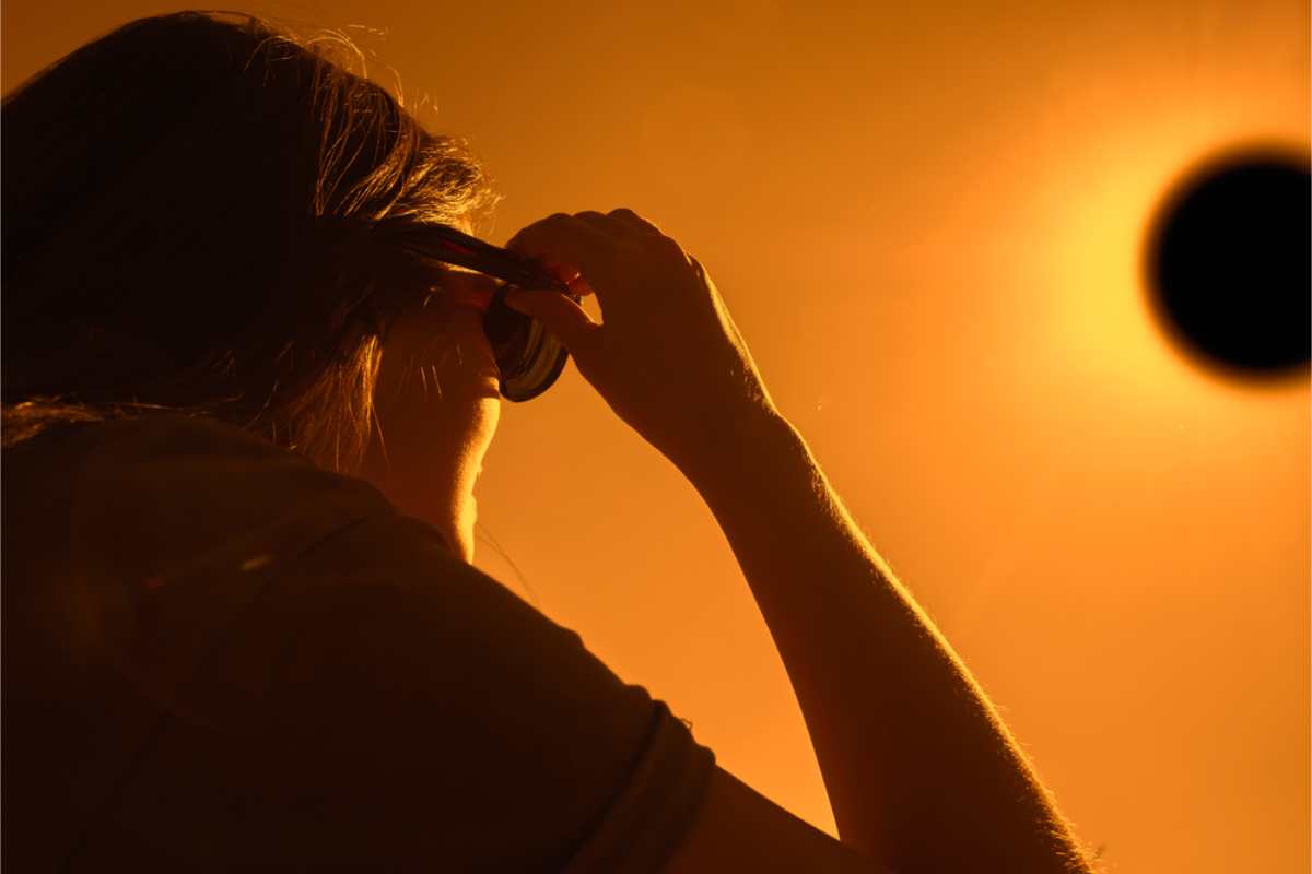 Woman watching a total eclipse with her eyes protected