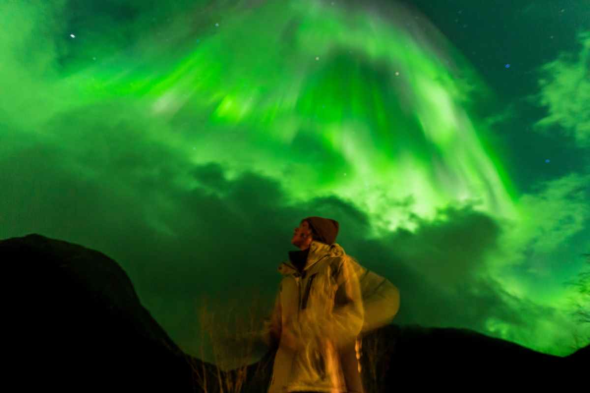 Meilleure période pour visiter l’Islande pour les aurores boréales Femme observant les aurores boréales au-dessus de son