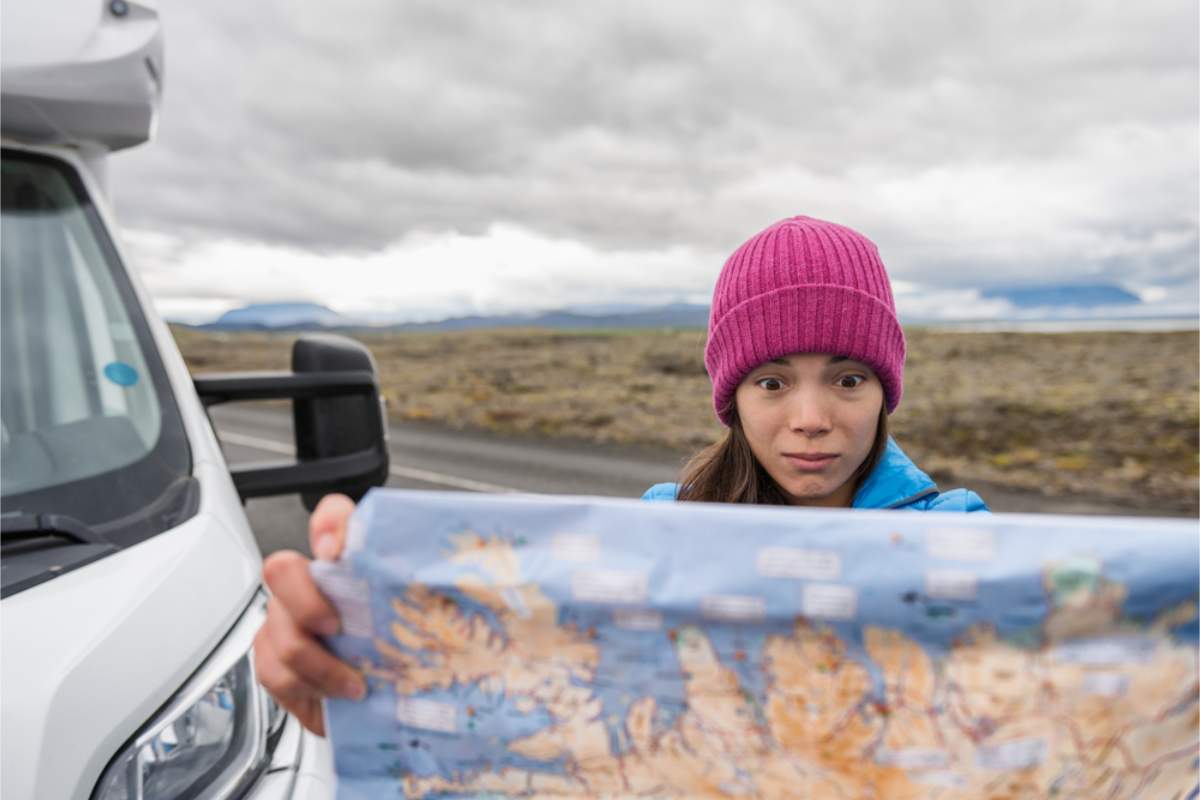 Woman holding a map of Iceland trying to find her next destination