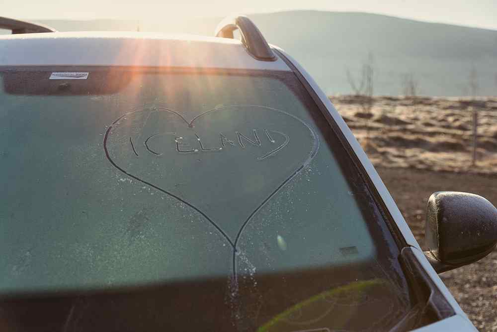 Cons of renting a car in Iceland The word Iceland drawn inside a heart on a frosty car windshield.