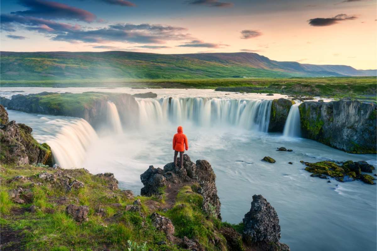 Tourist standing in front of Godafoss waterfall