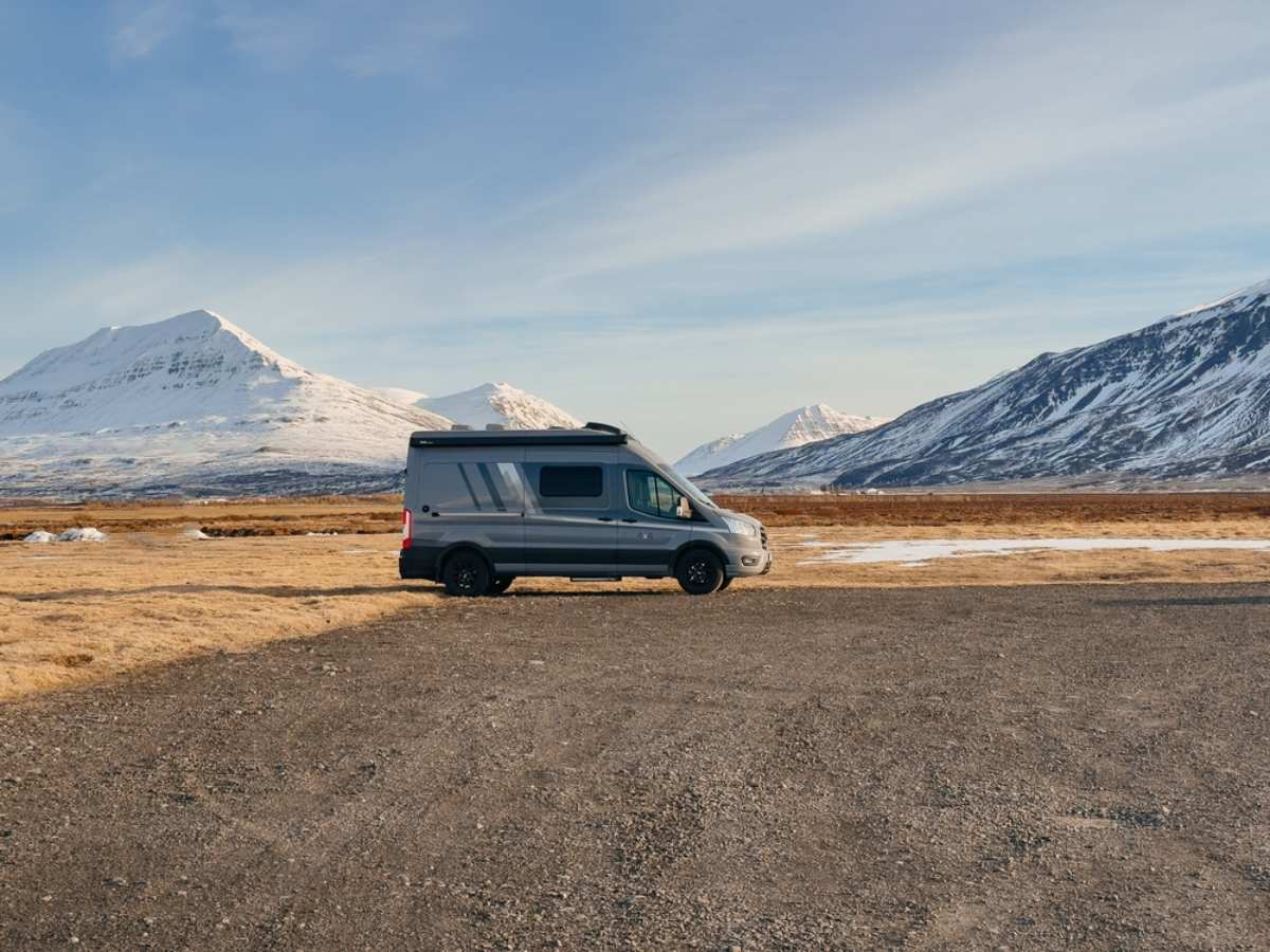 drive the Golden Circle in Iceland Camper parked in a beautiful barren area surrounded by snowed peaks