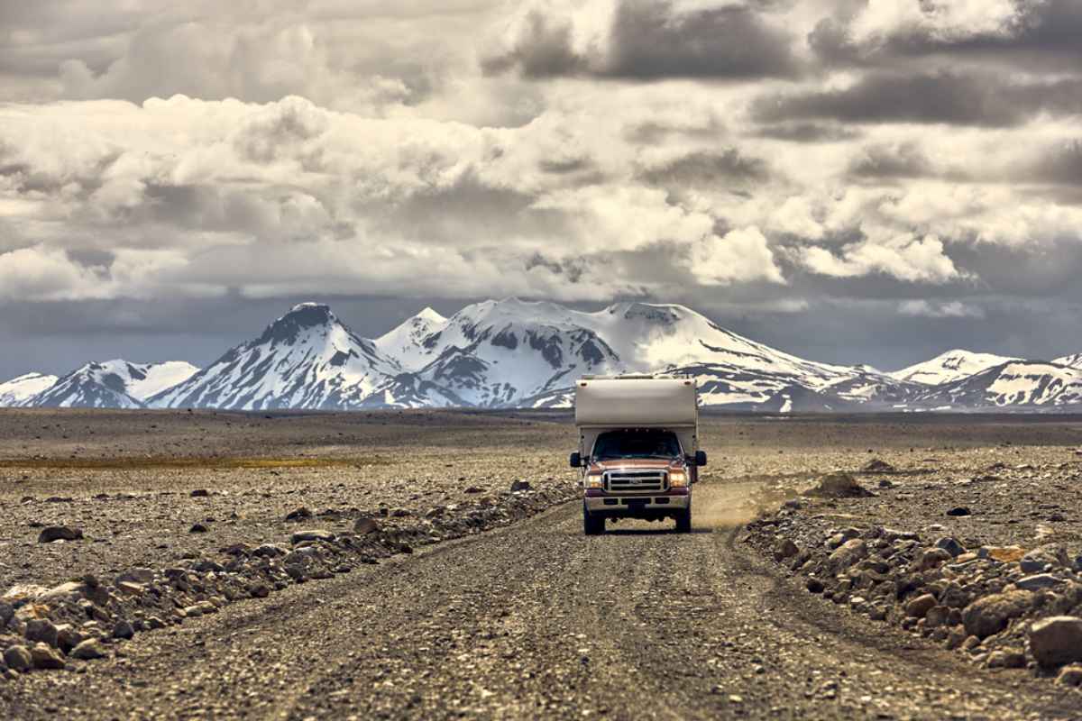 4x4 motorhome driving on an Icelandic road with huge mountains in the distance