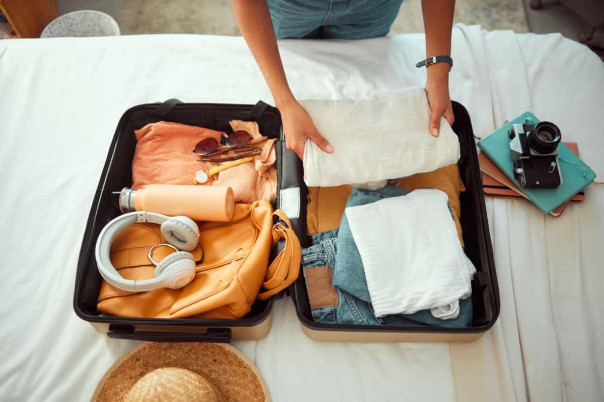 Tourist packing her suitcase with all the items needed for her Iceland trip