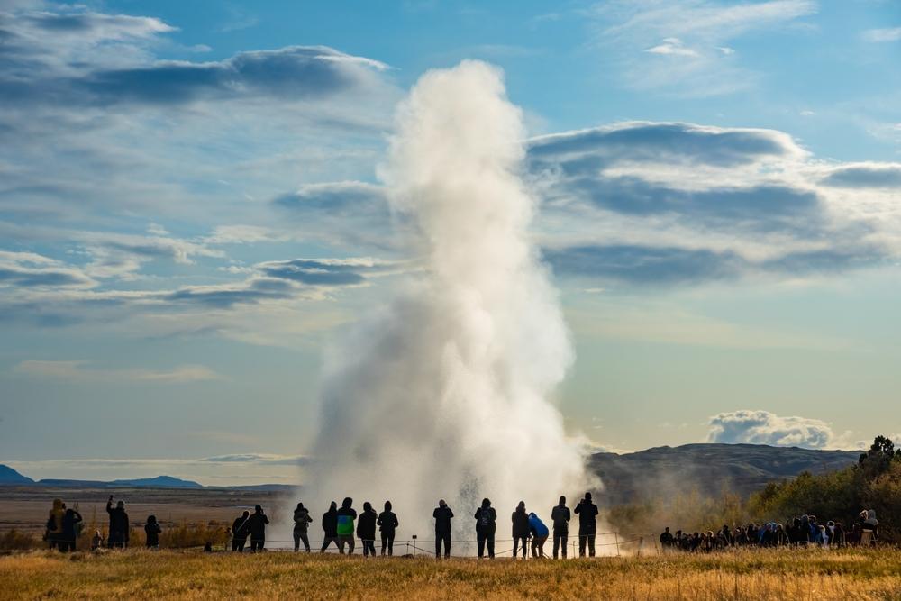 Pros and cons of Iceland in June Crowded sightseeing area in Iceland, with a geysir erupting