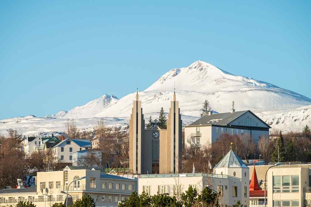 Akureyri church with snow-covered mountains rising behind the town.