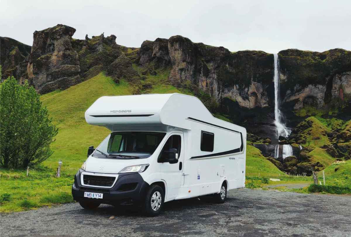 Large RV parked by a waterfall in Iceland