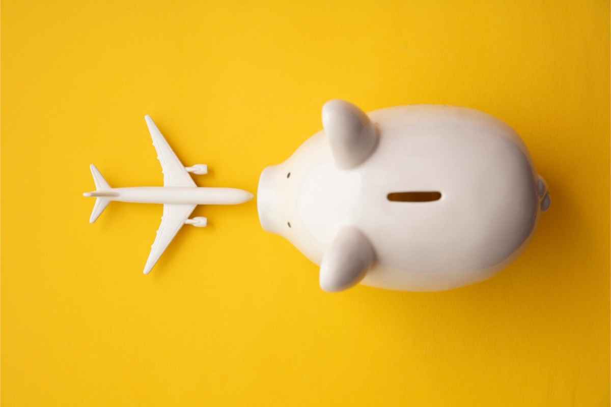 Piggy bank and an toy aircraft representing a cheap travel plan in Iceland