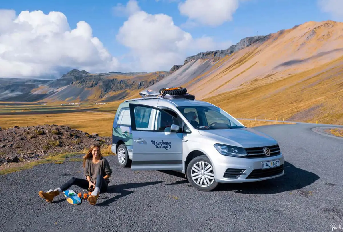 Tourist sitting by her motorhome Iceland camper out in the wild