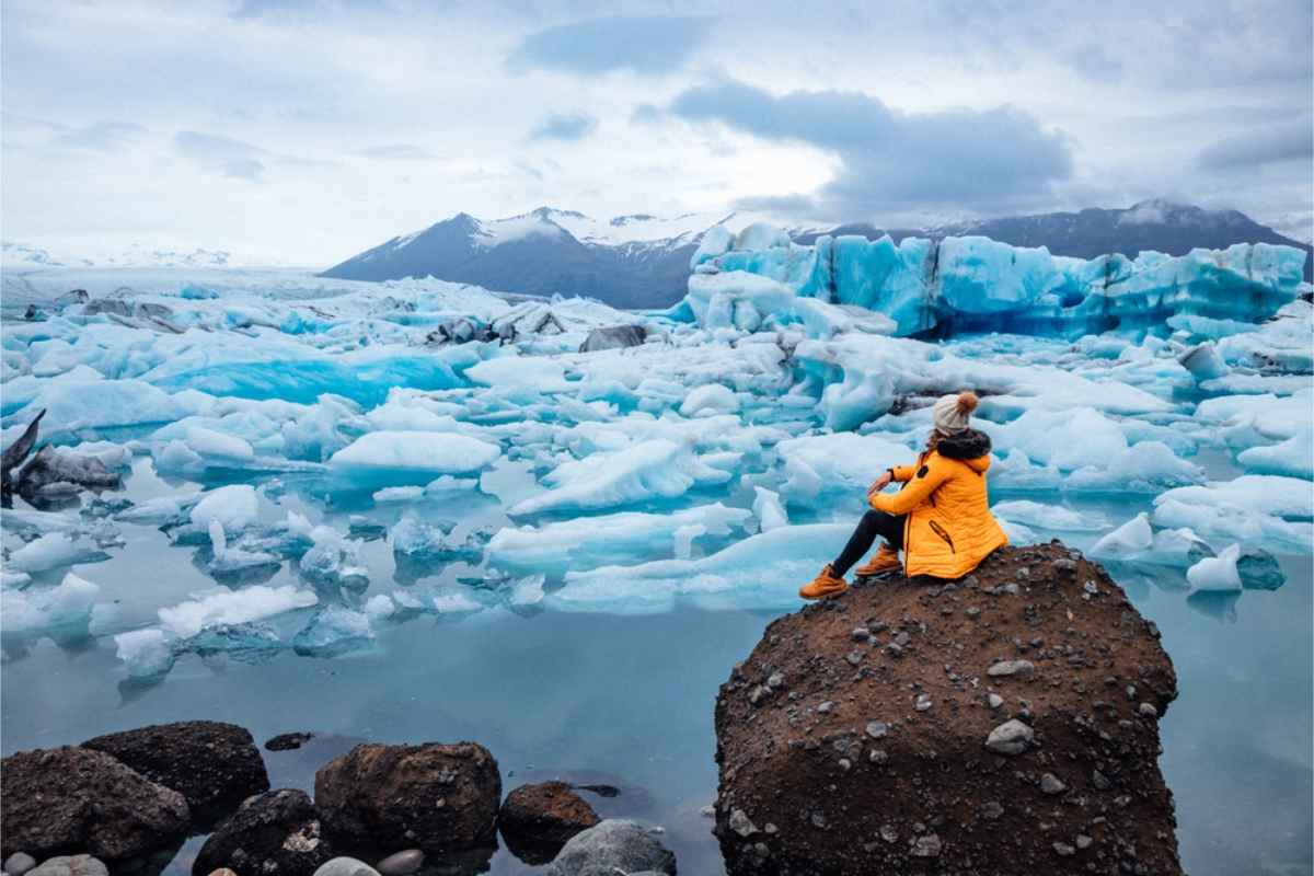 Tourist posing right in front of the freezing Jokulsarlon glacier lake